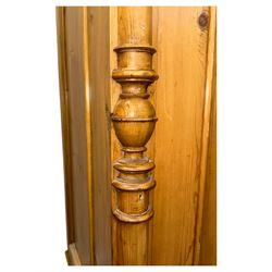 Large 19th-century Continental polished pine double wardrobe, panelled back and doors revealing brass hanging rod, flanked by half-turned columns with Corinthian capitals supported on bun feet