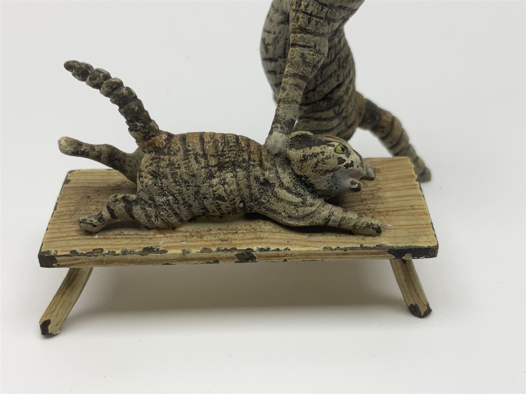 After Bergmann, two cold painted bronze figures, the first modelled as two cats on a bench hugging, the second a cat caning a kitten