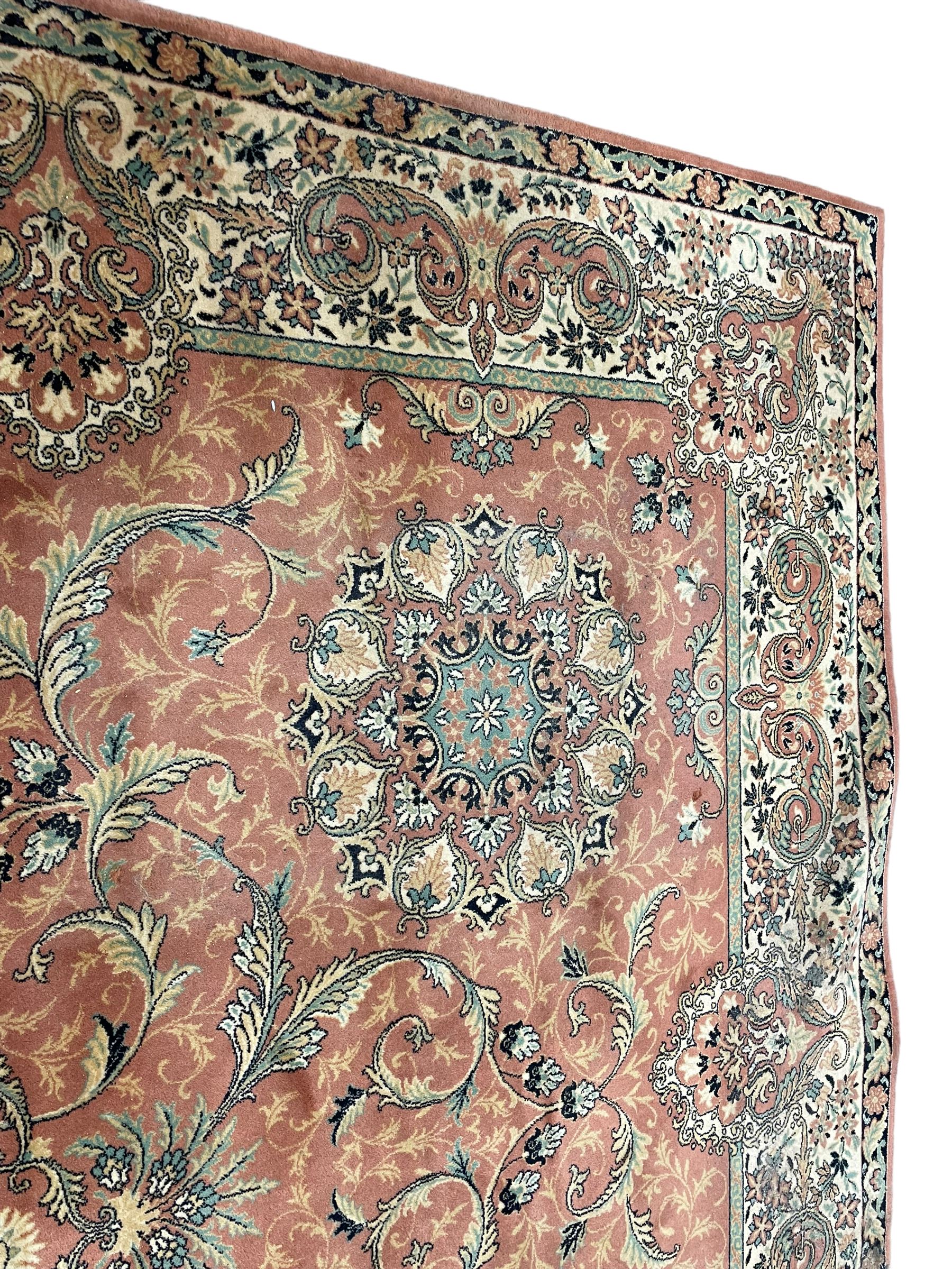 Persian design peach ground carpet, central floral medallion surrounded by scrolling foliage, decorated all over with stylised plant motifs, floral design repeating border
