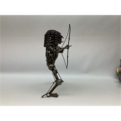 Predator metal sculpture, made with scrap metal, with articulated body, bike chain hair, and bow and arrow, H45cm