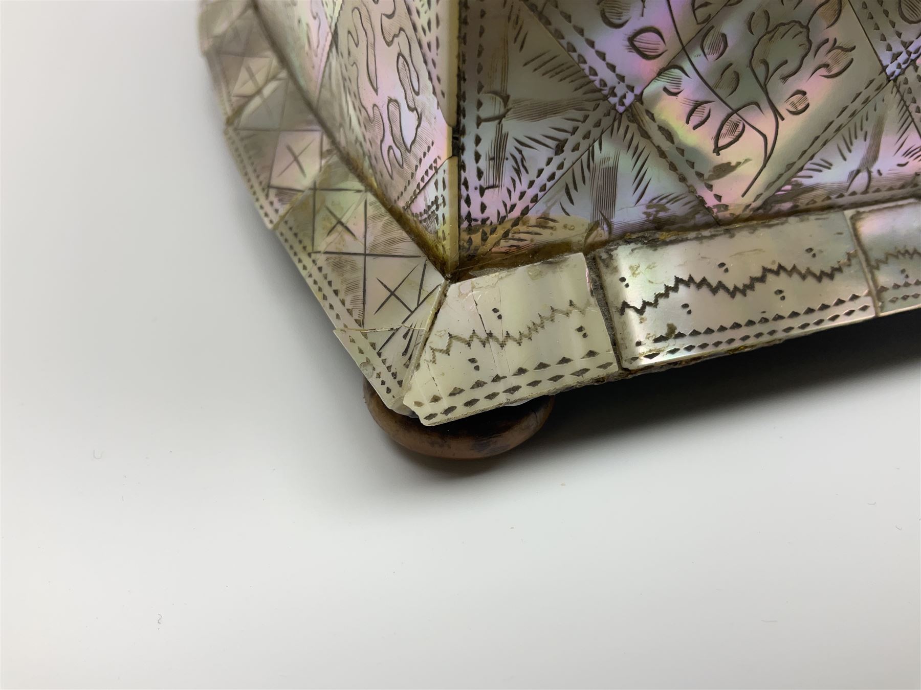 Victorian mother of pearl tea caddy, of rectangular bow-fronted form, the body with floral, bird and geometric engraved mother of pearl panels, white metal shield plaque to the cover inscribed with the initials G.J.A and similar escutcheon, the two division interior with ivory edging and two panelled mother of pearl lids, on four vegetable ivory bun feet L20cm, together with a similar style mother of pearl card case (2) This item has been registered for sale under Section 10 of the APHA Ivory Act