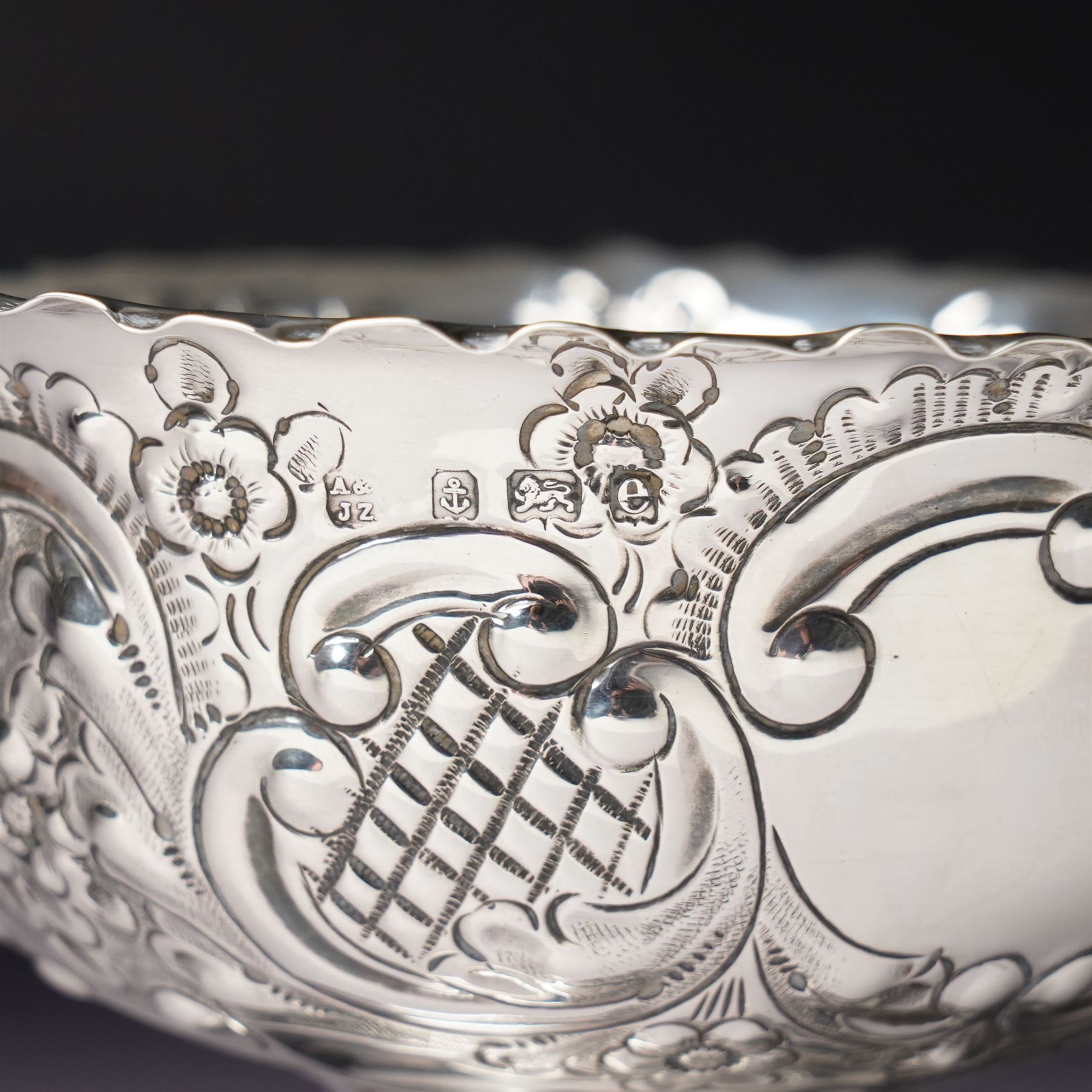 Edwardian silver bowl with embossed decoration on a short pedestal foot D11cm Birmingham 1904 Maker A & J Zimmerman Ltd and a modern silver coaster with turned wooden base D9.5cm Sheffield 2001 (2)