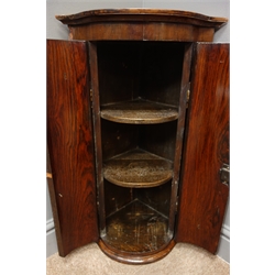  19th/20th century rosewood serpentine front wall hanging corner cabinet, projecting cornice, two cupboard doors enclosing three shelves, W39cm, H67cm, D29cm  