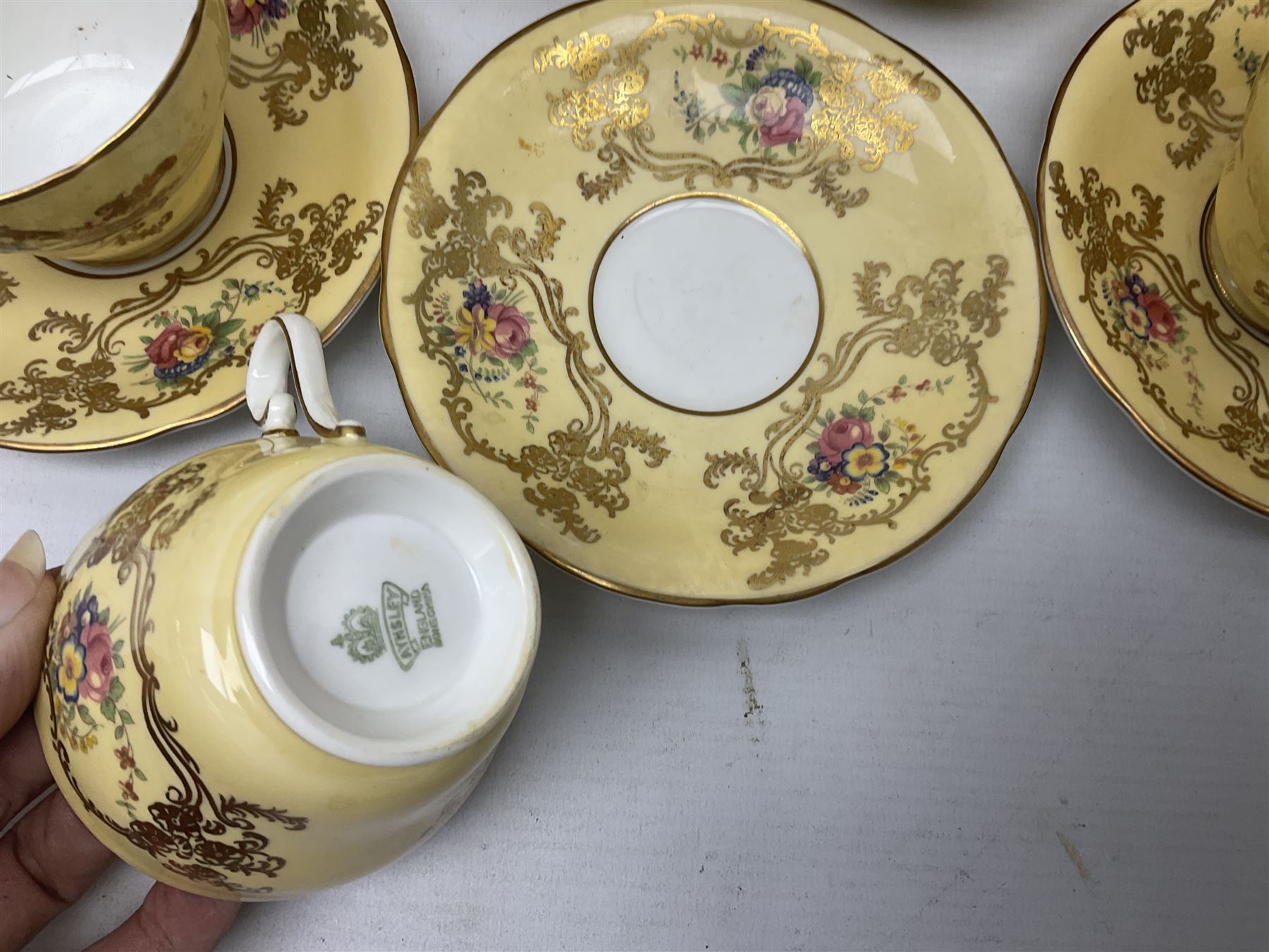Aynsley tea service for six, decorated with floral sprays in ornate gilt detailing on cream ground, comprising six teacups and saucers, open sucrier and milk jug and cake plate, all with printed marks beneath