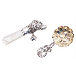 Unusual Victorian silver caddy spoon, the circular gilt bowl embossed with leaf and fruits, leading to a tendril handle also detailed with leaf and fruits, hallmarked Hilliard & Thomason, Birmingham, date letter indistinct, L8.5cm, together with a silver baby's rattle, in form of a spaniel, with mother of pearl handle, hallmarked Birmingham 1924, maker's mark W&H LD, approximate weighable silver 0.37 ozt (11.7 grams)