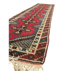 Turkish red ground runner, the field decorated with seven geometric star motifs, repeating geometric patterned border