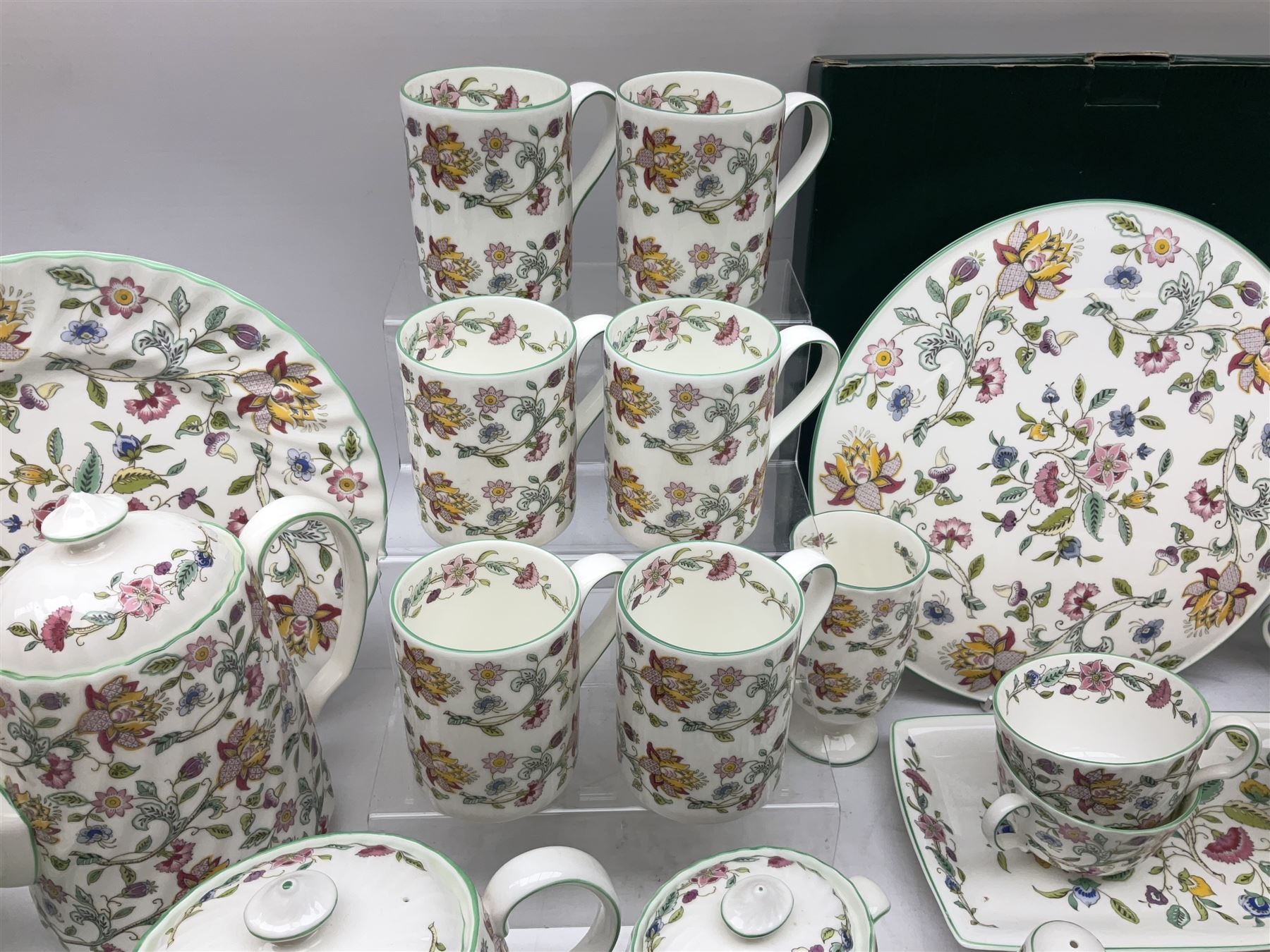 Minton Haddon Hall pattern tea and dinner wares, including basket dish, two covered tureens, six dinner plates, eight dessert plates, twelve tea plates, six soup bowls, six cereal bowls, teapot, coffee pot, milk jug, covered sucrier twelve tea cups and saucers, six mugs, footed bon bon dish, pair of candlestick holders, cake knife and slice etc (81)