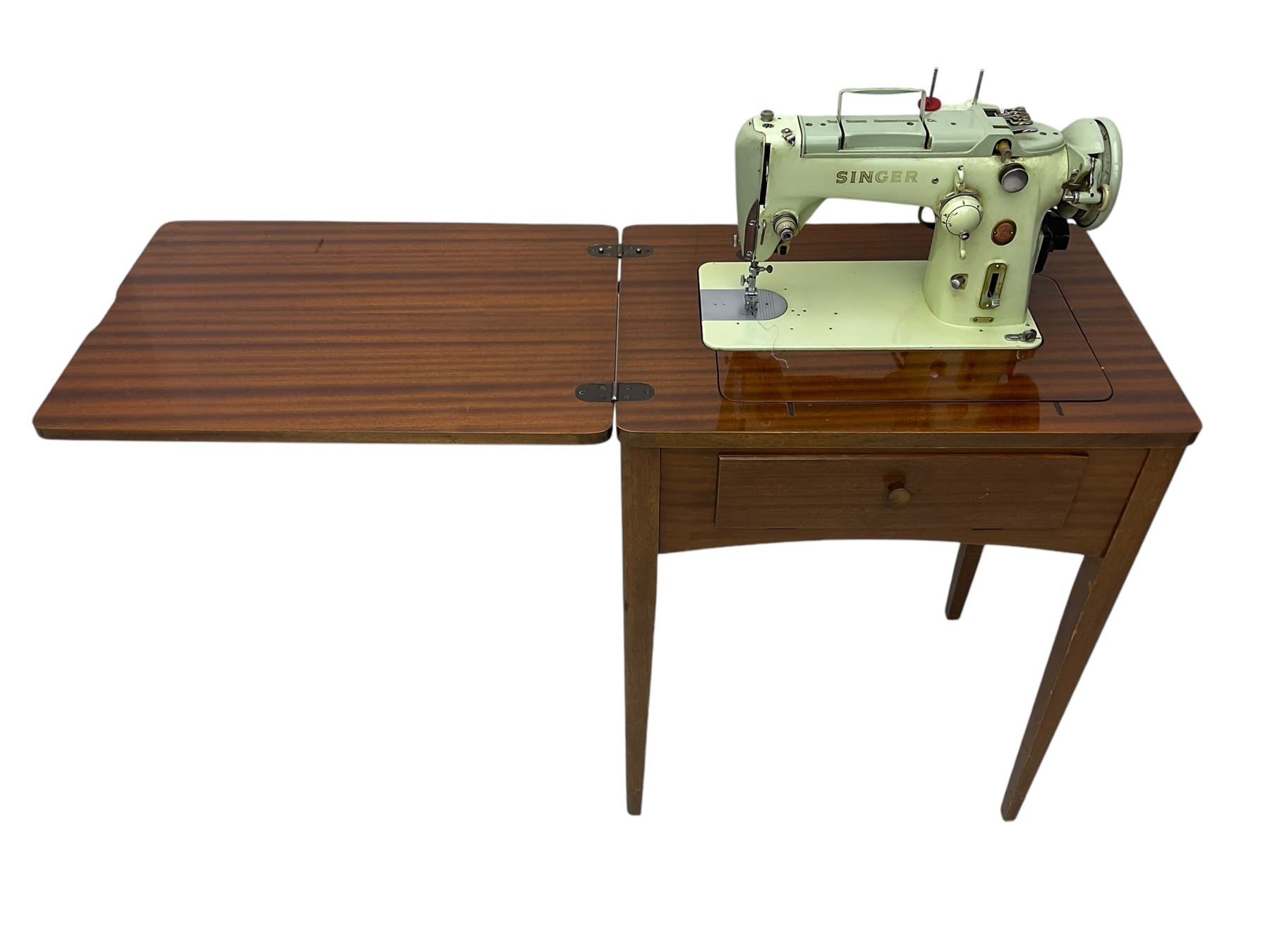 Mid-20th century teak sewing table, rectangular top with hinged fold-out extension revealing built-in Singer sewing machine, fitted with single hinged drawer, on square tapered supports; various Singer accessories to include Fashion Discs and Motor Controller