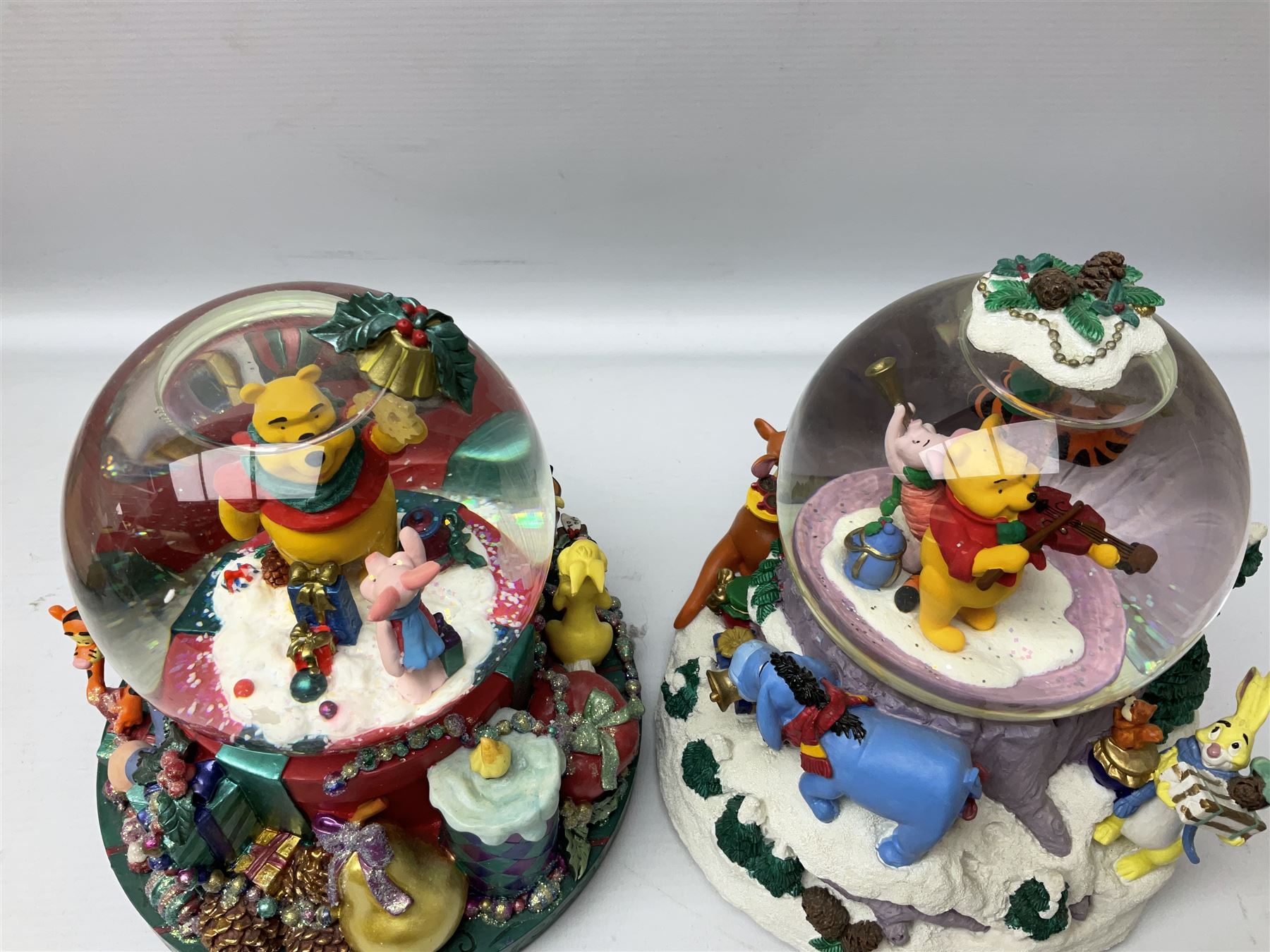Six Disney Winnie the Pooh Christmas snow globes, comprising large Mr Christmas Holiday Snowfall, An Enchanted Christmas, It's A Small World Christmas 1994,  Tree Trimming, 1995 Christmas At Our House and Christmas Band Concert, together with Mr Christmas Holiday Go Round, all with boxes (7)