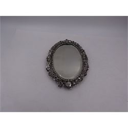 Continental silver miniature dressing table/wall mirror, of oval form with bevelled mirror plate, surrounded by a bead and dart rim, with pierced scrolling floral border with a standing cavalier to either side and the bust of a cavalier to the base, H17.7cm