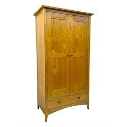 Contemporary light oak double wardrobe, projecting cornice over two panelled doors enclosing hanging rail and shelf, above full-width drawer, on shaped stile supports