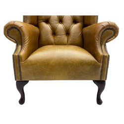 Georgian design wingback armchair, high back with shaped cresting rail over scrolled arms, upholstered in buttoned tan leather with stud-work border, raised on cabriole supports