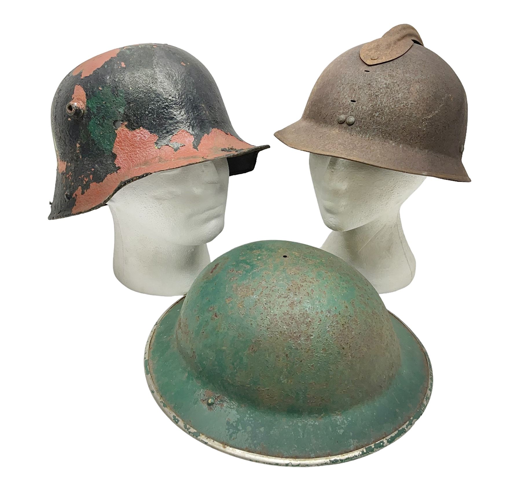 Three battlefield relic helmet shells - WWI German M16; WWI French Adrian; and WWII British (3)