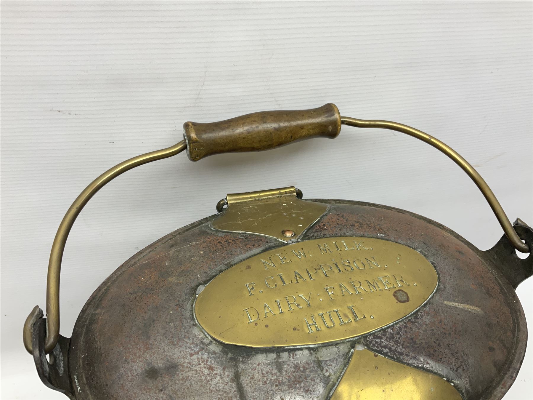 Late 19th/early 20th century steel and brass dairy pail or can, of oval form with swing handle, brass plaque to front and hinged cover inscribed 'F & T Ross Ltd Dairy Outfitters Hull', and 'New Milk F Clappison Dairy Farmer Hull', not including handle H30cm