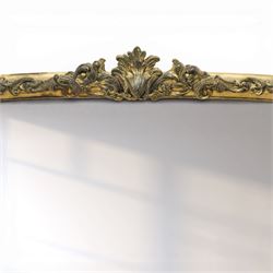 Regency style gilt overmantle mirror, arched rectangular frame with moulded surround, surmounted by a central anthemion and scrolling foliate crest, the frame enriched with beaded and foliate mouldings, the lower corners with applied scroll terminals, enclosing a single rectangular mirror plate
