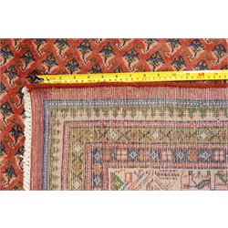 West Persian Boteh-Mir hand-knotted rug, madder red field densely decorated with a repeating lattice of of small boteh motifs arranged in diagonal rows enclosed by a broad border of stylized geometric devices and angular floral ornament between multiple guard stripes with cotton fringe ends