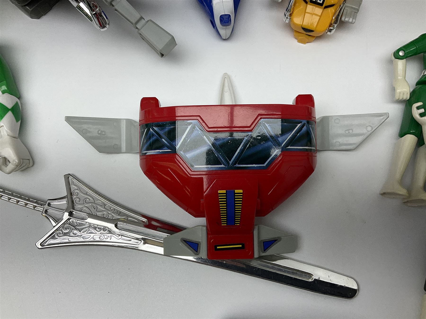 Collection of early 90s Mighty Morphin’ Power Rangers Zords, figures and accessories. Titanus the Carrier Zord, marked Bandai 1991; Green Dragonzord, incomplete; 1994 White Tigerzord with original instruction manual; 1993 Triceratops Dinozord, Mastodon Dinozord and Sabertooth Tiger Dinozord, Pterodactyl Dinozord, missing guns; with 1993 Power Morpher and original Power Coins, with further related figures, accessories and weapons