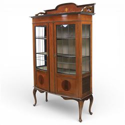 Edwardian mahogany display cabinet, arched back with satinwood and harewood marquetry foliate decoration above a moulded cornice, serpentine front fitted with twin glazed doors with astragal bars, the lower door panels inlaid with oval reserves, standing on elegant cabriole legs terminating in pad feet