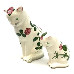 Two Plichta pottery cat figures, the largest example hand painted with clover leaves and flowers, with printed mark beneath, H14cm, the smaller example hand painted with thistles, with printed mark beneath, H8cm. 