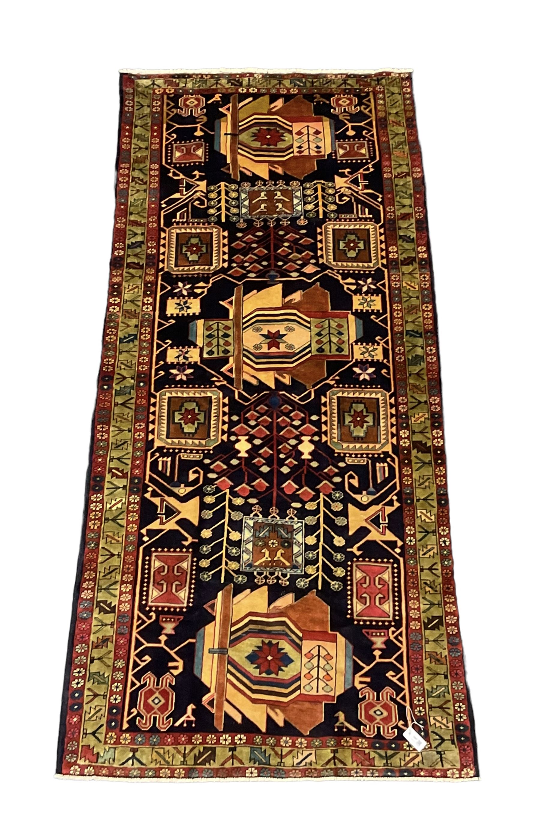North West Persian Heriz Kelleh rug, the blue ground field with large stylised plant medallions, decorated with flower head, bird and tree of life motifs, triple band foliate pattern borders 