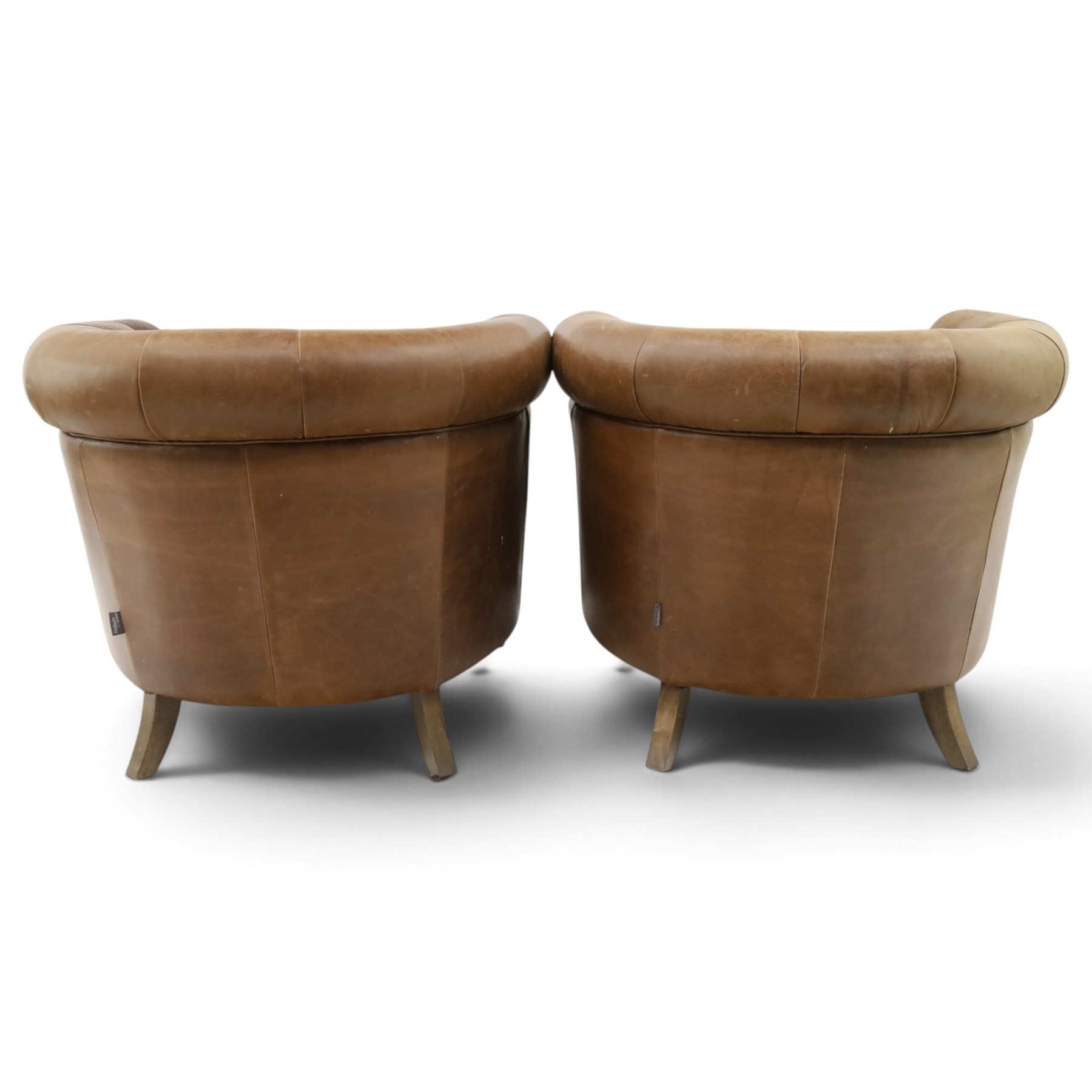 Alexander and James - pair of 'Jude' tub armchairs, traditional tub shape with buttoned back over deep seat, with studwork to the arm terminals, raised on turned front supports and splayed rear supports