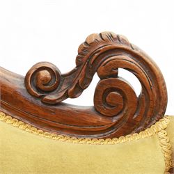Victorian walnut chaise longue, carved with scrolling acanthus to the end supports and seat rail, upholstered in mustard coloured velvet, shaped and buttoned back and side with turned spindle gallery, raised on short turned legs with ceramic castors 