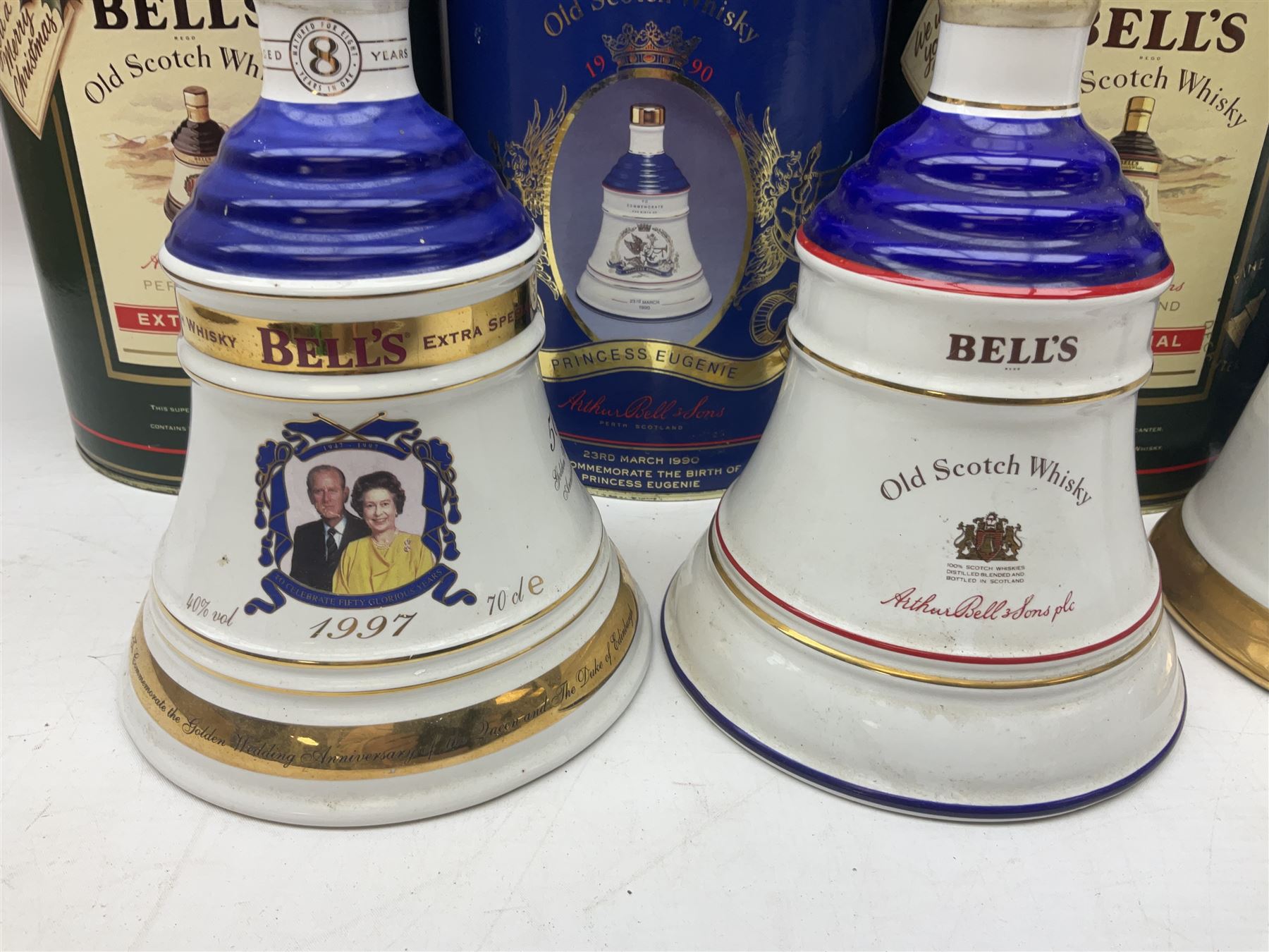 Bells, Scotch whisky, in seven Wade ceramic decanters, comprising two Christmas decanters 1990 and 1991, 60th birthday of Queen Elizabeth II decanter, Golden Wedding anniversary of the Queen and the Duke of Edinburgh decanter, Birth of Princess Beatrice decanter, Birth of Princess Eugenie decanter and Queen's mothers, together with Bells, blended Scotch whiskies, three miniatures in Wade ceramic decanters, various contents and proofs