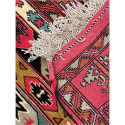 Turkaman red ground rug, the field divided into horizontal rows and decorated with geometric motifs, intricately pattern borders and end panels