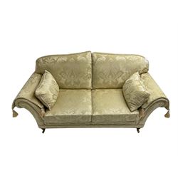 Steed Upholstery - two seat traditional shaped sofa, upholstered in cream fabric with scrolling foliate pattern, on turned front feet with brass castors, with side cushions and arm covers