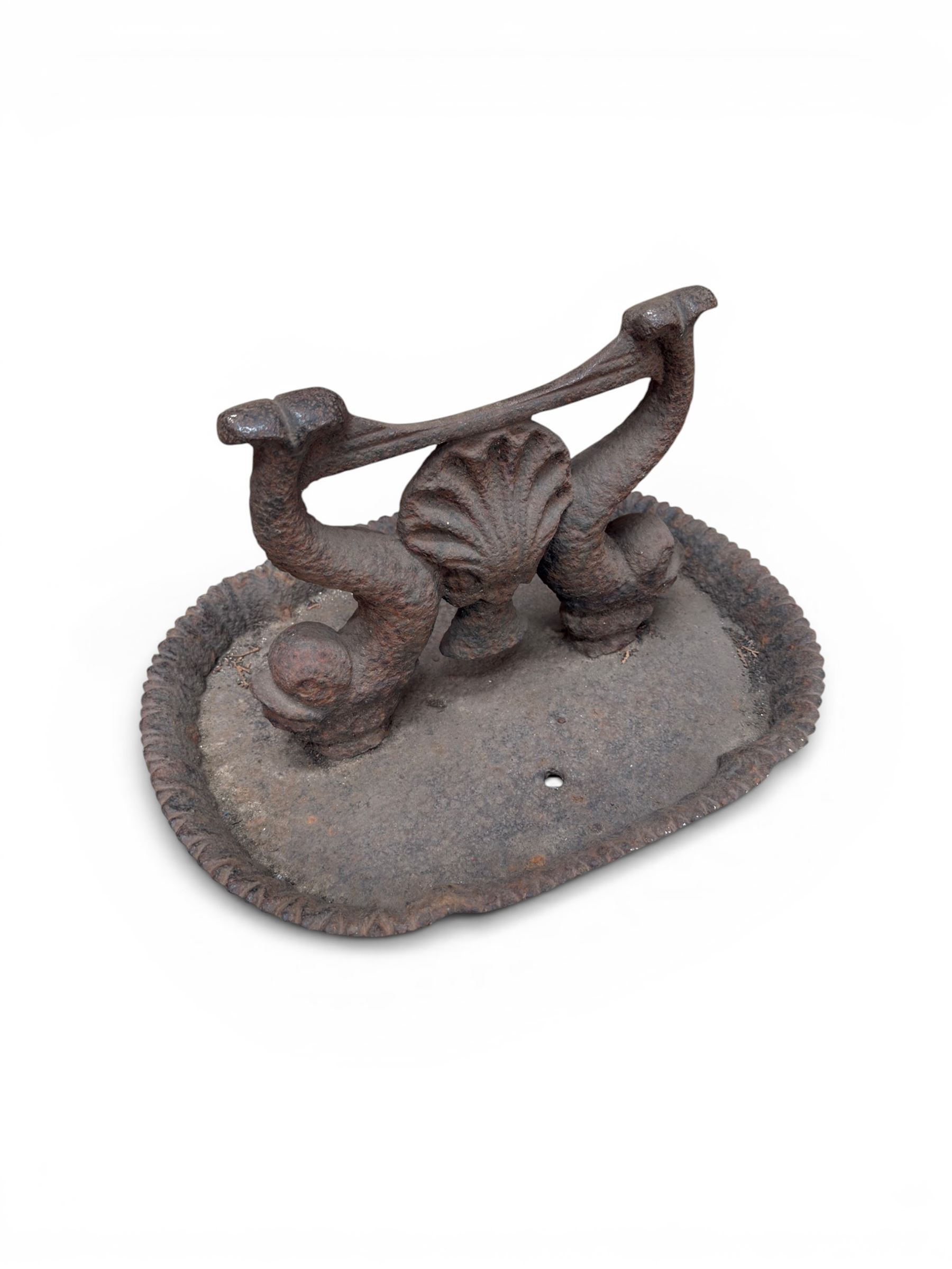 Victorian cast iron boot scraper, supported by two dolphins with central shell motif
