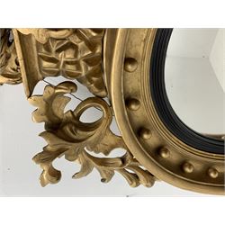 Large Regency carved wood and gesso circular convex mirror, eagle pediment on platform flanked by acanthus leaf scrolls, moulded surround and ebonised slip