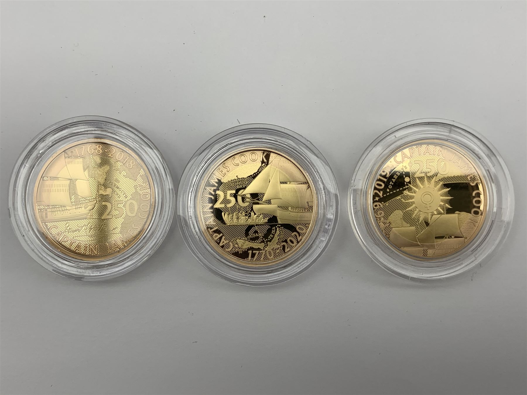 Captain Cook gold proof three coin series, comprising 2018, 2019 and 2020 dated gold proof two pound coins, all three housed together in a Royal Mint presentation box, the individual boxes and certificates are also present