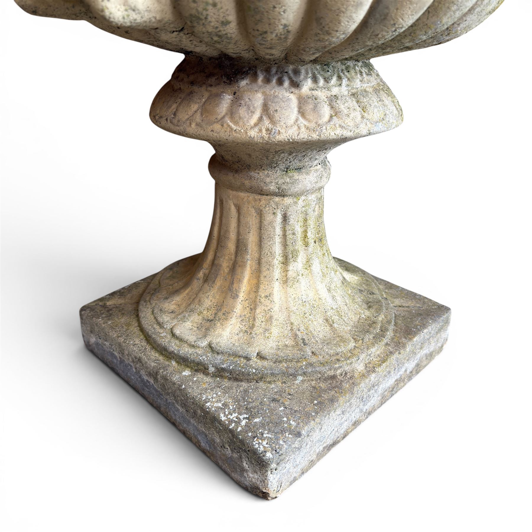 Pair of large cast stone garden urns, circular form with egg and dart border, tapering gadrooned bowl with cast handles and detail