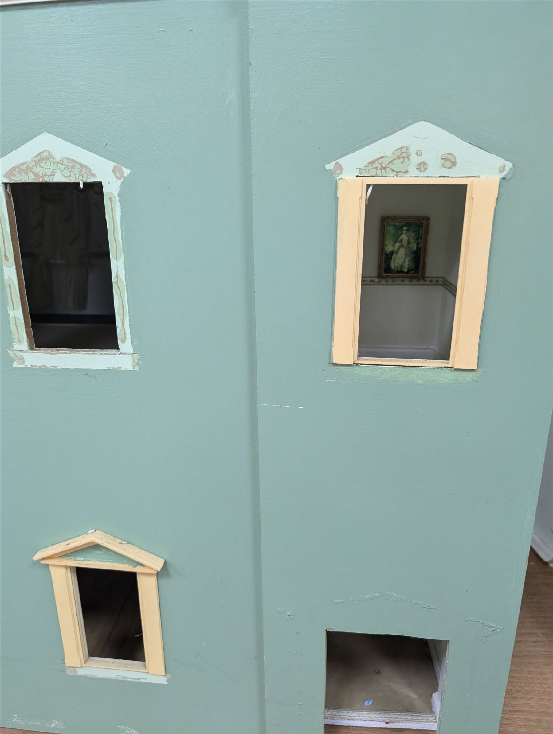 Two modern three storey dolls houses, each painted green with decorated interiors, both upon a single white wooden base, together with a large collection of dolls house furniture, accessories and figures 