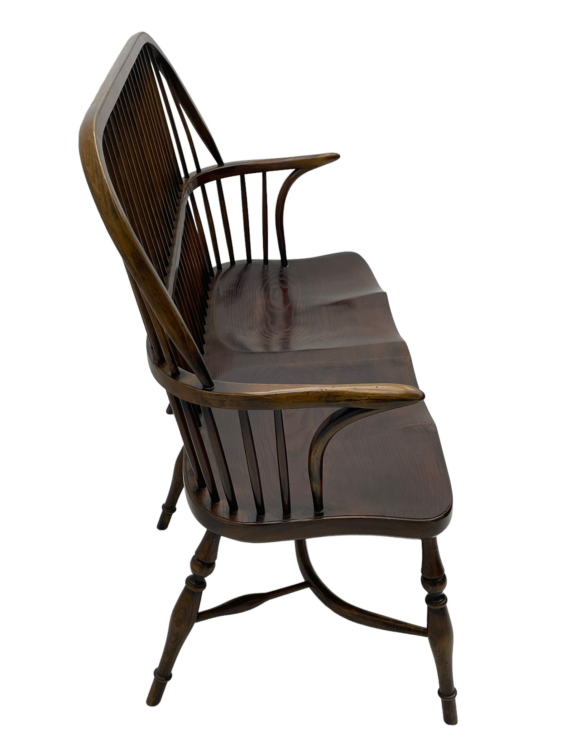 Traditional elm and oak two seat Windsor bench, high comb and stick back, double dished seat on turned supports joined by two crinoline stretchers