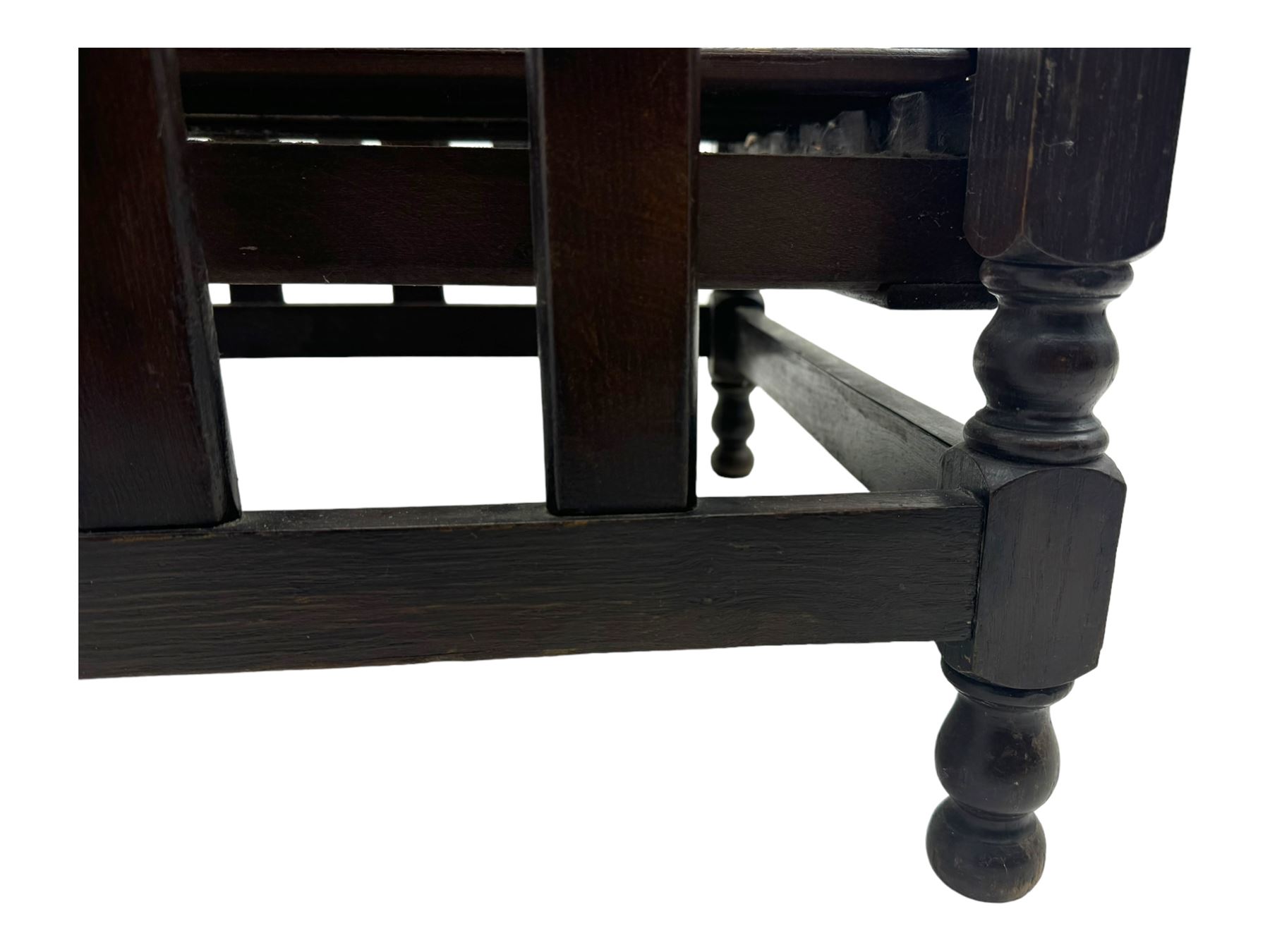 Late Victorian oak steamer chair, adjustable slatted backrest with grooved crest rail, wide armrests extending to a sliding adjustable footrest, open frame sides with vertical slats, side magazine rack and collapsible table, raised on turned front supports