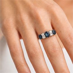 18ct gold sapphire and diamond ring, three graduating oval cut sapphires, the principal stone with two round brilliant cut diamonds set either side, London 1975, total sapphire weight approx 2.70 carat