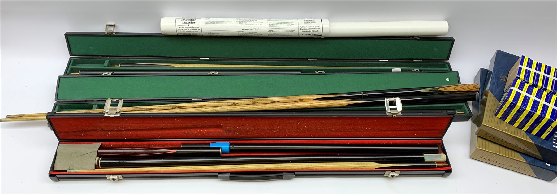 Collection of various snooker cues to include a Lewis & Wilson cue, Master Cue Makers, two other cues, three hard cases, two boxes of Snooker Balls, twelve boxes of chalk and related posters