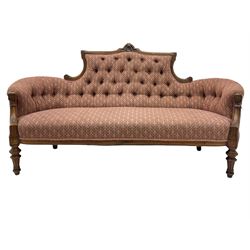 Victorian walnut settee, raised shaped back with pierced decoration, curved ends and buttoned back, upholstered in patterned fabric, turned and fluted front feet