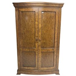 Regency design walnut bow-front double wardrobe, enclosed by panelled doors