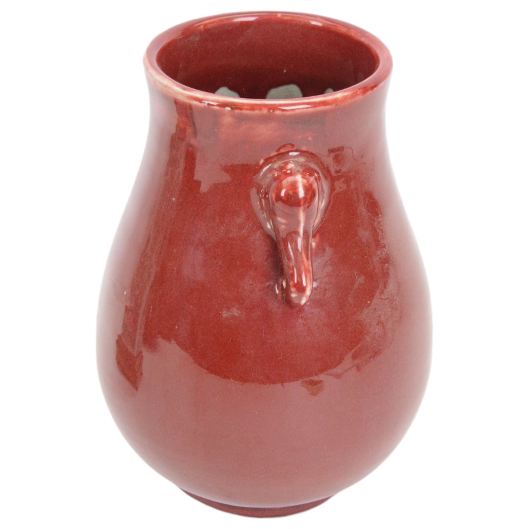 20th century Chinese sang de boeuf vase of baluster form with elephant head handles, togehter with a pair of famille rose vases decorated with floral decoration and insects, upon wooden stands   