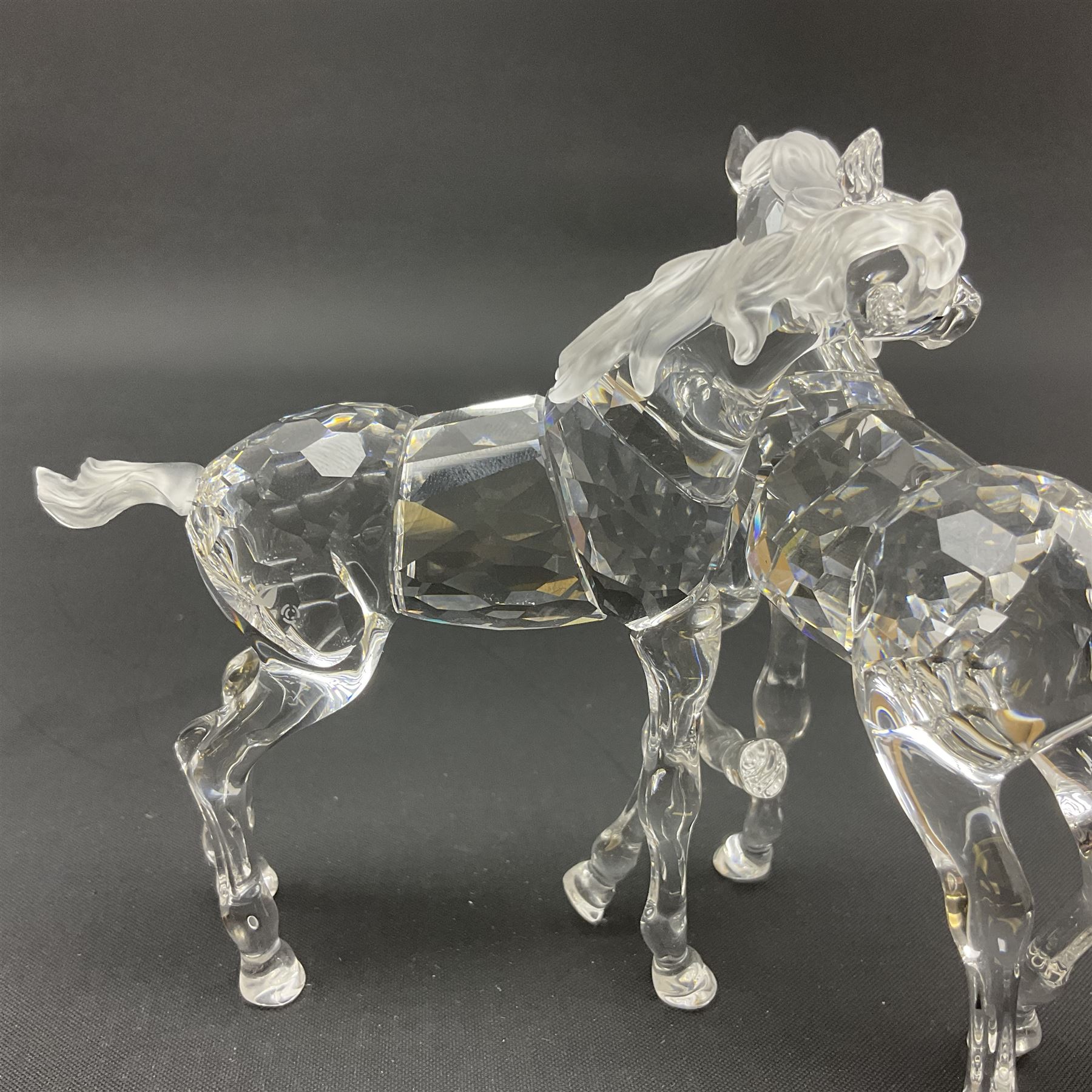 Five Swarovski Crystal horses, comprising stallion, rearing horse, pair of horses playing and Arabian stallion, each with frosted manes and tails, together with a small Swarovski Crystal galloping horse, the mane, tail and base with smoky tint