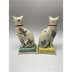 Pair of 19th century Staffordshire cats, modelled seated upon cushions and decorated with polychrome floral sprays, H18.5cm