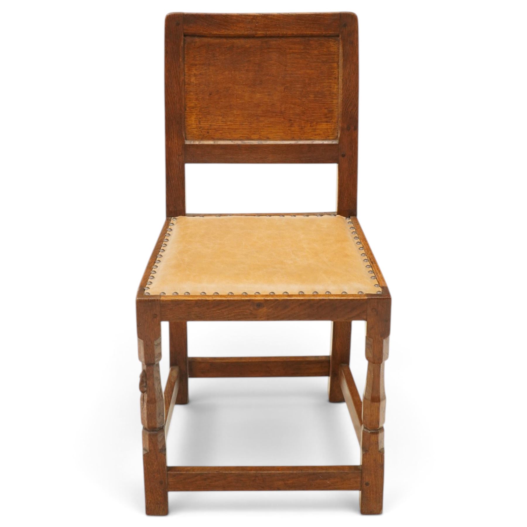 Mouseman side chair- panelled adzed back over tan leather upholstered seat with studwork, on octagonal front supports united by stretchers, each with signature carved mouse, by the workshop of Robert Thompson, Kilburn