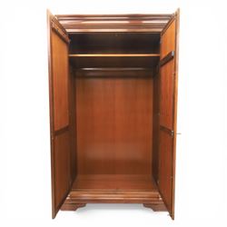 Willis & Gambier - French cherry double wardrobe, moulded cornice above panelled doors, enclosing a shelf and wooden hanging rail, raised on a moulded plinth with bracket feet