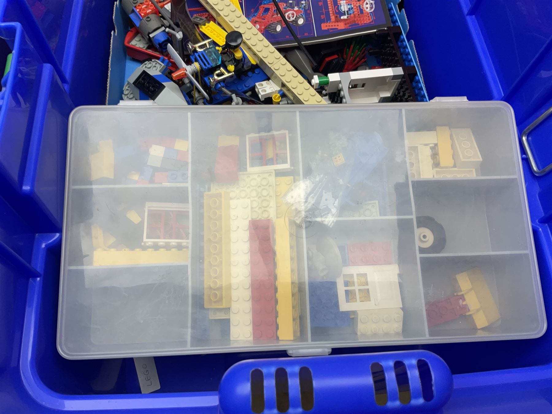 Lego - large quantity of part-built models and loose component parts including Lego Technic and Lego System, space and road vehicles, ships and boats, helicopter etc; together with two set boxes and folder  containing large quantity of instruction booklets; stored in two very large plastic boxes