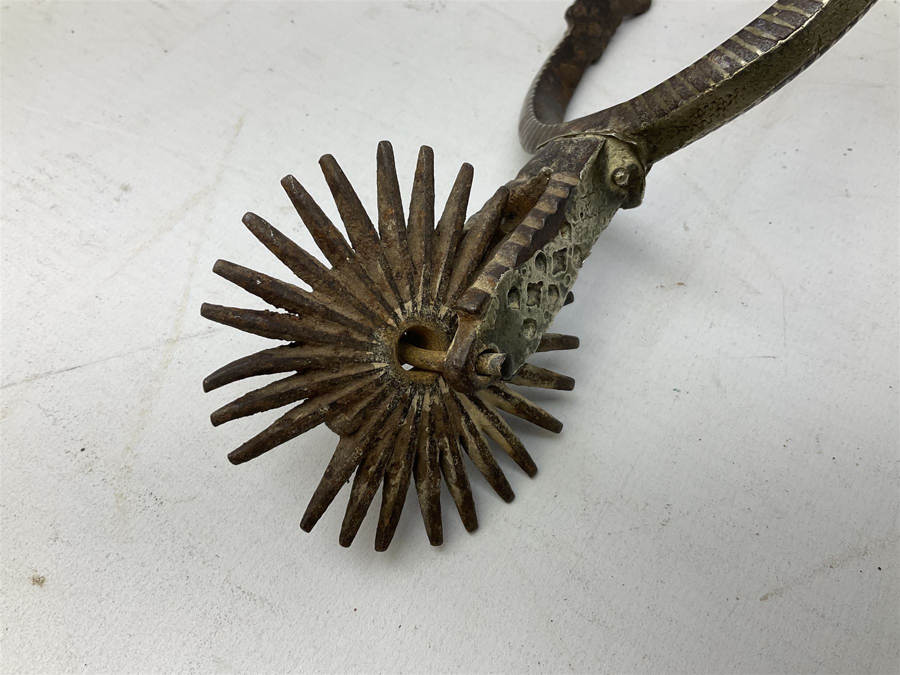 Pair of late 19th century South American iron spurs, engraved silver mounts, with sunburst rowls