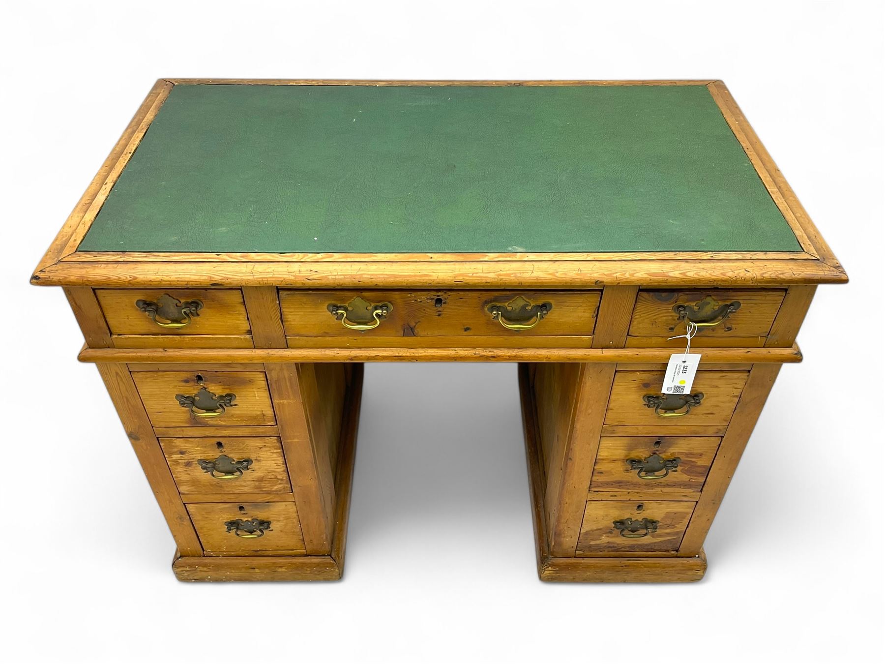 Rustic pine twin pedestal desk, rectangular green leather inset top above a central frieze drawer flanked by two short drawers, each pedestal featuring three graduated drawers, raised on a plinth base
