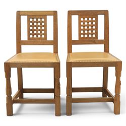 Mouseman - set of four oak lattice back chairs with tan seat with brass studded trim, with carved mouse signature, by the workshop of Robert Thompson of Kilburn