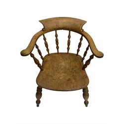 Late 19th century elm smoker’s bow armchair, curved top rails over turned spindle backs, shaped seats, raised on turned legs united by turned stretchers; together with a similar smoker’s bow armchair (2)